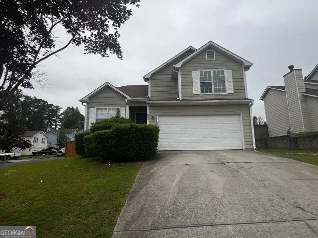 view of front of home with a garage and a front lawn