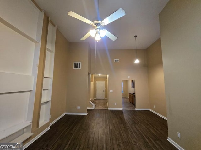 unfurnished living room with dark hardwood / wood-style floors and ceiling fan