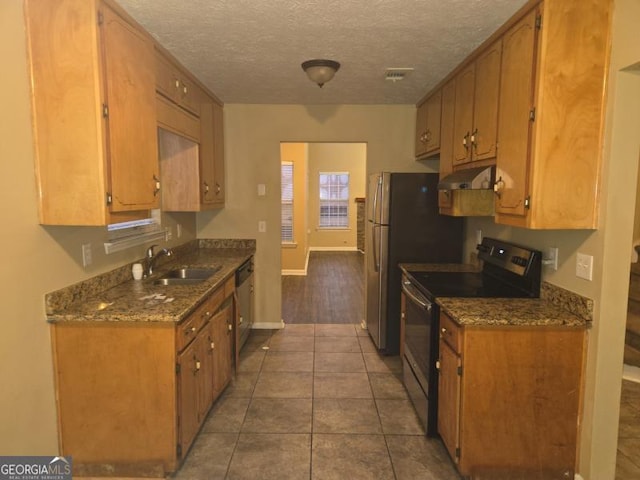 kitchen with stainless steel appliances, sink, a textured ceiling, and dark tile patterned floors