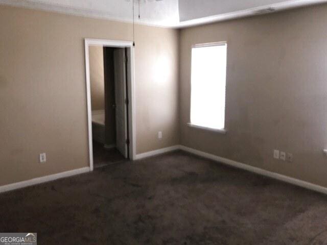 unfurnished bedroom with dark colored carpet