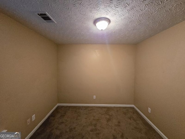 carpeted spare room featuring a textured ceiling