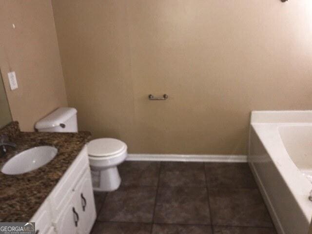 bathroom featuring vanity, a washtub, and toilet