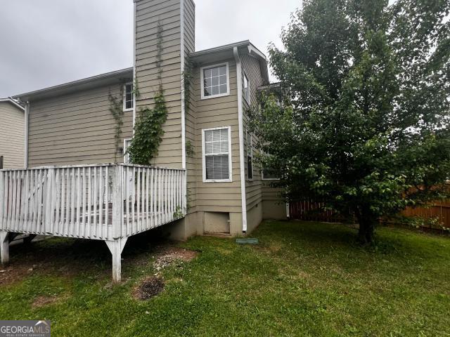 view of side of home featuring a lawn and a deck