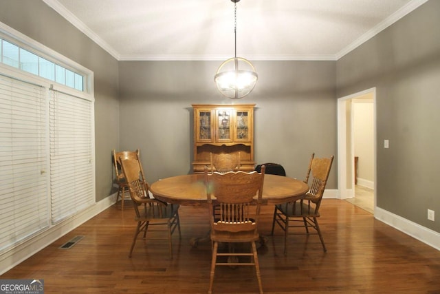 dining space with dark wood-type flooring and crown molding