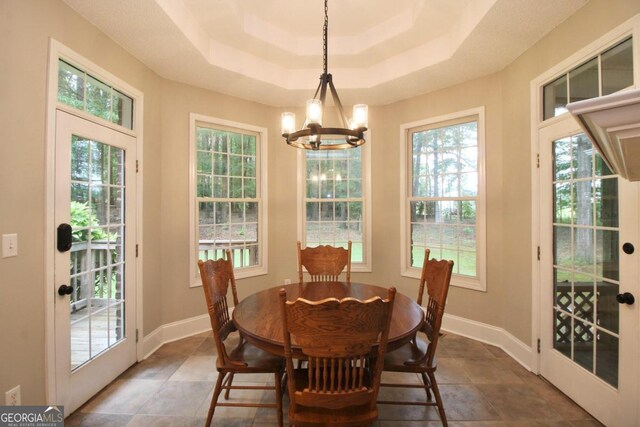 dining space with a wealth of natural light, a notable chandelier, and tile flooring