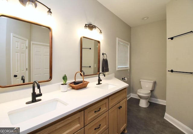 bathroom with double vanity, toilet, and tile floors