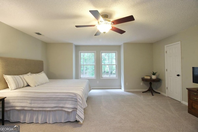 bedroom featuring carpet, ceiling fan, and a textured ceiling