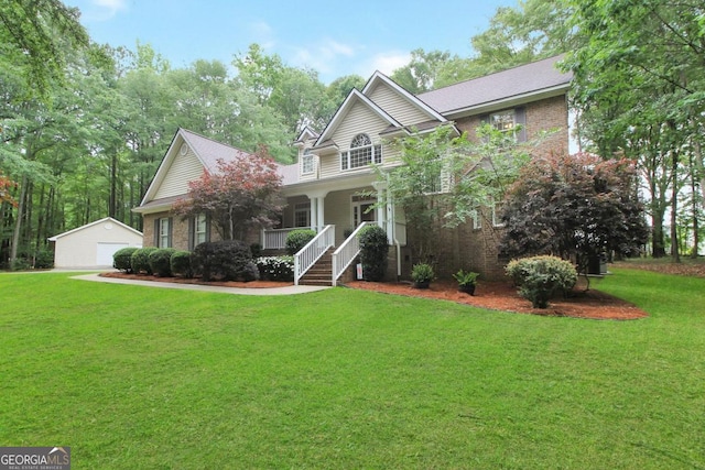 view of front of property featuring a front yard, an outdoor structure, a garage, and covered porch