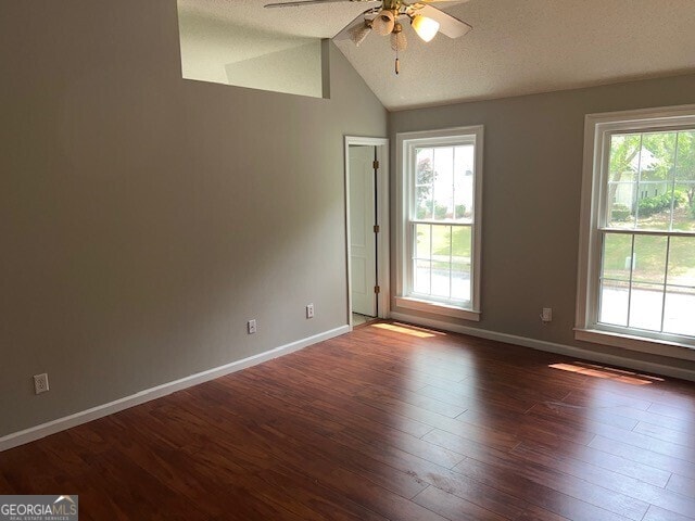 unfurnished room featuring dark hardwood / wood-style flooring, ceiling fan, a textured ceiling, and lofted ceiling