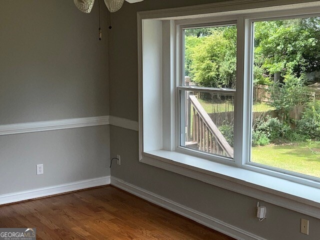 empty room with dark wood-type flooring and ceiling fan