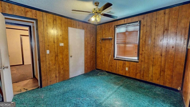 unfurnished bedroom featuring dark carpet, ornamental molding, and ceiling fan