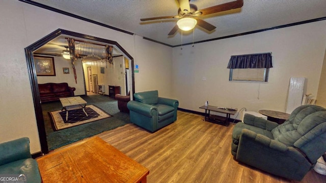 living room with a textured ceiling, ornamental molding, ceiling fan, and hardwood / wood-style floors