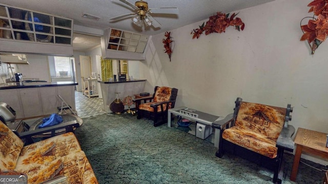 carpeted living room featuring a textured ceiling and ceiling fan