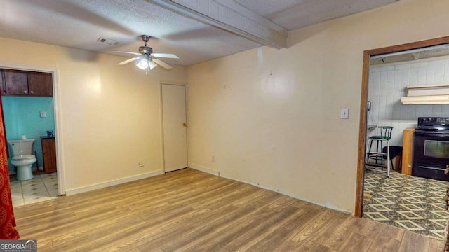 tiled empty room featuring ceiling fan and a textured ceiling