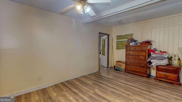 bedroom with beam ceiling, hardwood / wood-style flooring, and ceiling fan