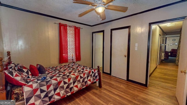 bedroom with hardwood / wood-style floors, ceiling fan, and a textured ceiling