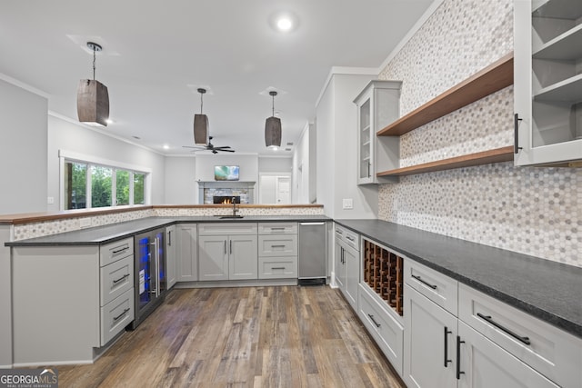 kitchen with ornamental molding, a stone fireplace, backsplash, and dark wood-type flooring