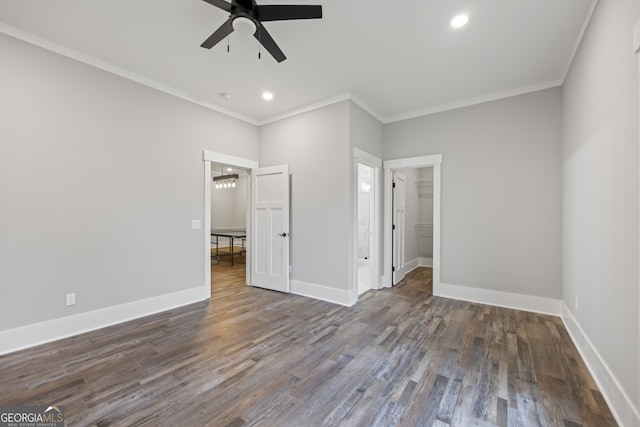 unfurnished bedroom featuring ornamental molding, ceiling fan, hardwood / wood-style floors, and a walk in closet