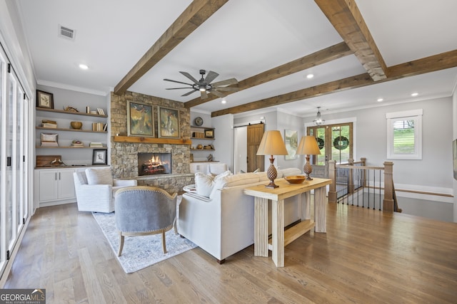 living room with a fireplace, beamed ceiling, light hardwood / wood-style flooring, and ceiling fan