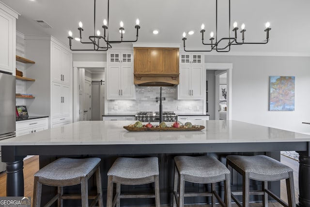 kitchen featuring decorative light fixtures, white cabinetry, and a spacious island