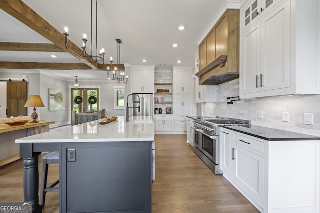 kitchen featuring sink, range with two ovens, white cabinets, and a large island