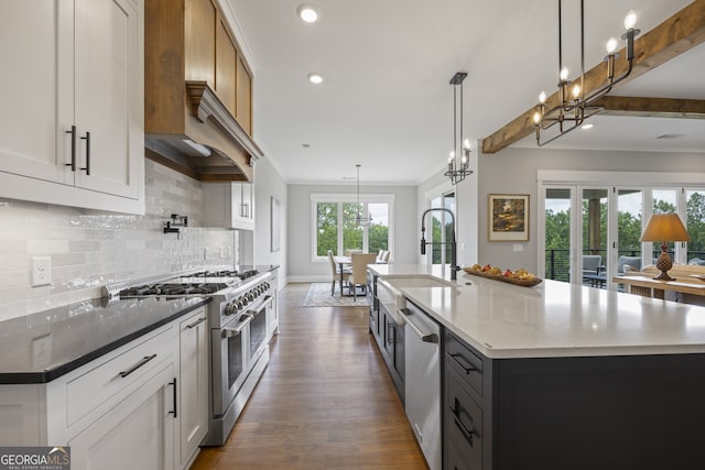 kitchen with appliances with stainless steel finishes, white cabinets, light stone counters, and a spacious island