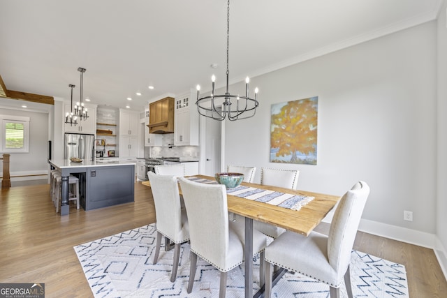 dining area featuring ornamental molding, light hardwood / wood-style flooring, and a chandelier