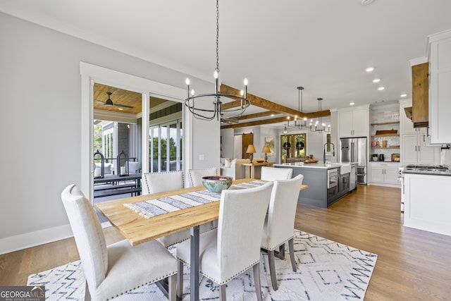 dining area featuring crown molding, light hardwood / wood-style flooring, and a chandelier