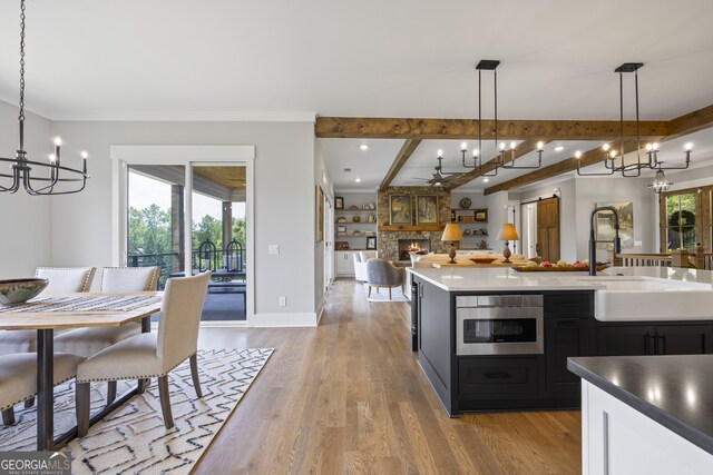 kitchen with plenty of natural light, a fireplace, light wood-type flooring, and pendant lighting