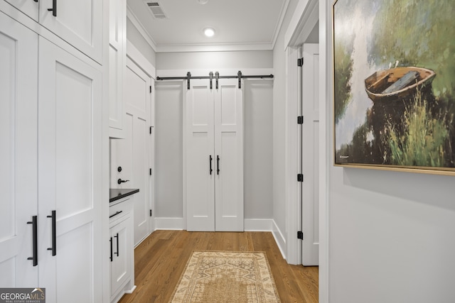 mudroom with crown molding and light wood-type flooring