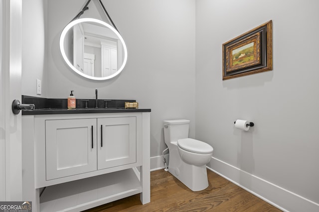 bathroom featuring hardwood / wood-style flooring, toilet, and vanity