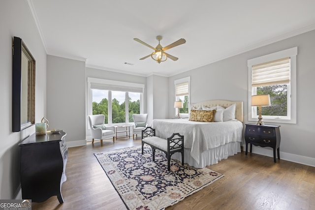 bedroom with multiple windows, hardwood / wood-style flooring, and ceiling fan