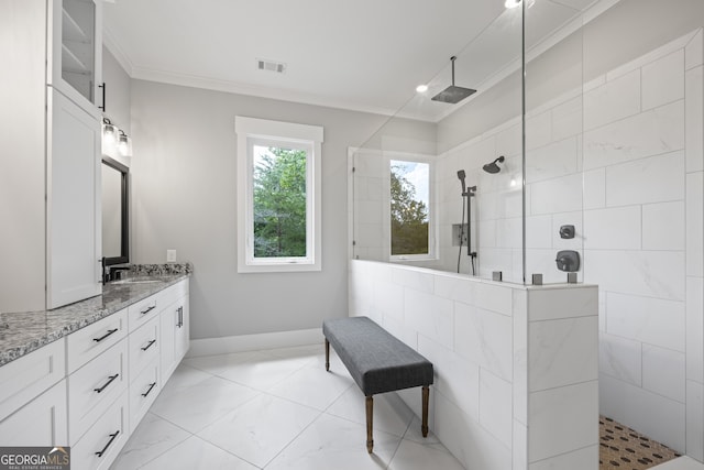 bathroom featuring dual vanity, a tile shower, tile patterned flooring, and crown molding