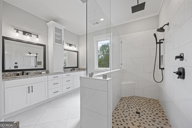 bathroom featuring dual bowl vanity, ornamental molding, a tile shower, and tile patterned floors