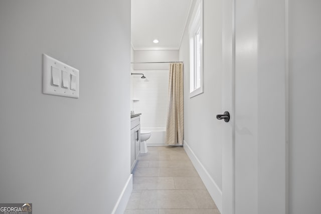 hall featuring light tile patterned flooring and ornamental molding