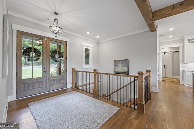 entryway featuring beam ceiling, french doors, an inviting chandelier, a barn door, and dark hardwood / wood-style floors