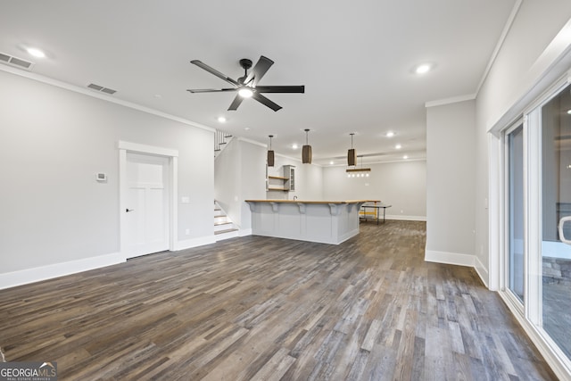 unfurnished living room featuring wood-type flooring, ceiling fan, and crown molding