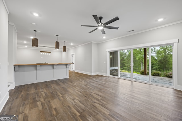 unfurnished living room featuring ornamental molding, ceiling fan, and dark hardwood / wood-style floors