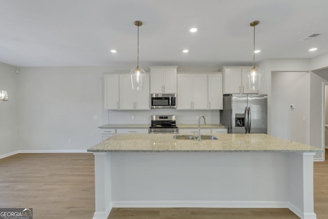 kitchen featuring sink, decorative light fixtures, stainless steel appliances, and white cabinets