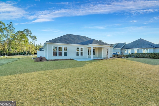 rear view of property with a patio and a lawn