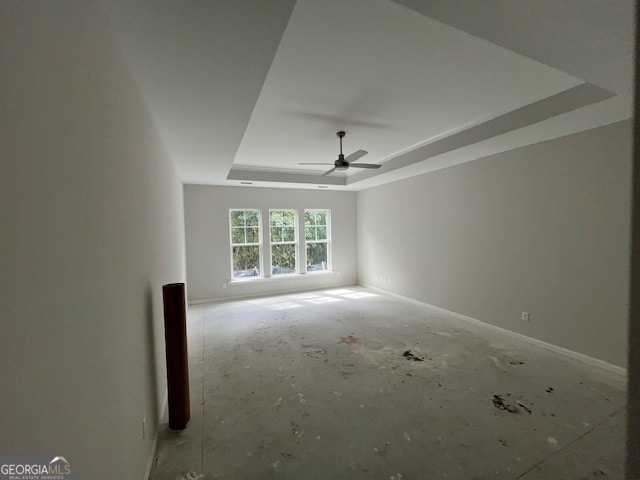 empty room with a tray ceiling and ceiling fan