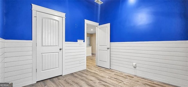 unfurnished bedroom with a closet and light wood-type flooring