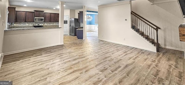 kitchen featuring backsplash, appliances with stainless steel finishes, light hardwood / wood-style flooring, and dark brown cabinetry