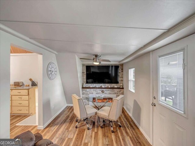 dining room with hardwood / wood-style floors, ceiling fan, and a fireplace