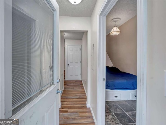 hall featuring tile floors and a textured ceiling