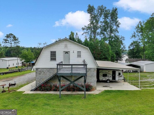 rear view of property with a carport and a yard