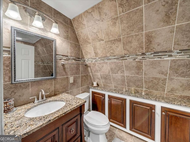 bathroom featuring tile walls, backsplash, toilet, tile flooring, and vanity