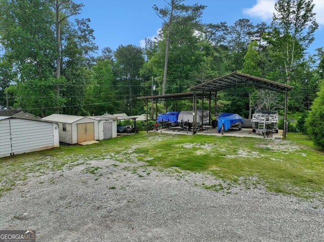 view of yard with a storage unit and a carport