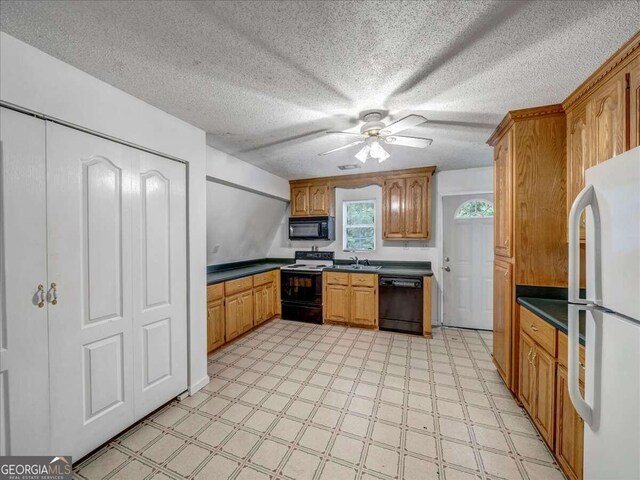 kitchen featuring ceiling fan, black appliances, a textured ceiling, light tile floors, and sink