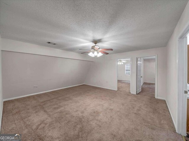 unfurnished bedroom with a textured ceiling, ceiling fan, and carpet floors